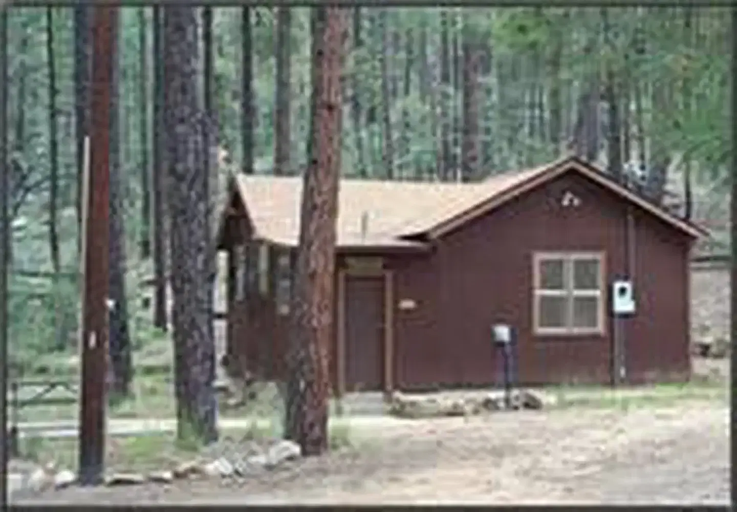 Exterior of Horsethief cabin sitting in the ponderosa with picnic table to the left
