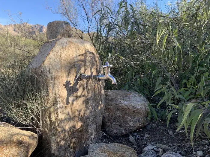 silver water spigot coming out of a rock