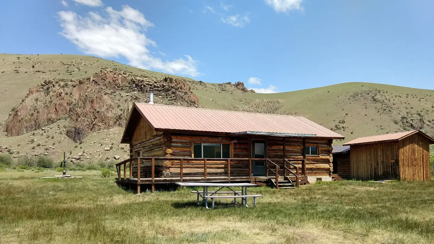 Front view of Stone Cellar Guard Station, a classic log cabin with ADA access ramp and awning over the front door