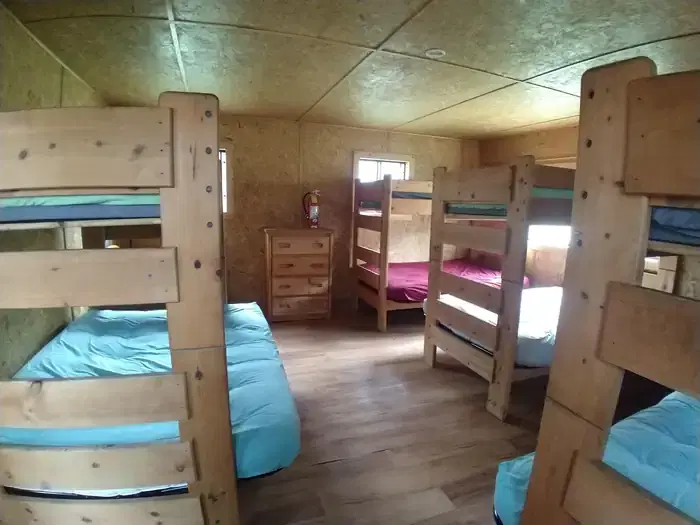 large bedroom with 4 bunk beds and a dresser